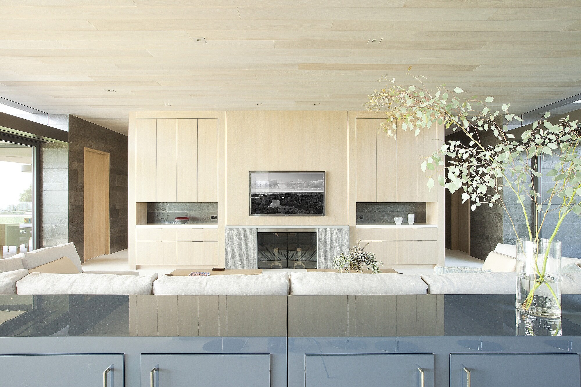 A living room with pale oak built-ins around a fireplace